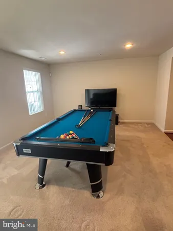a room with furniture pool table and windows