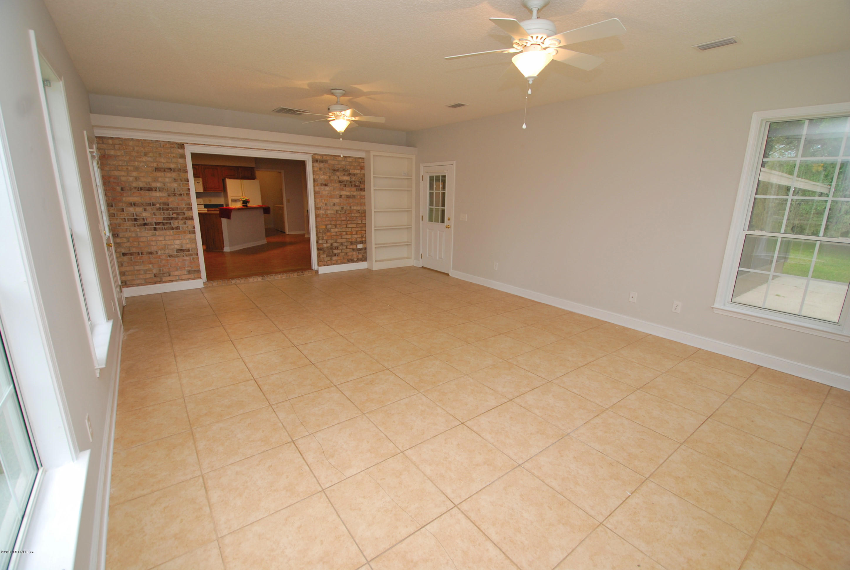 55581 Deer Run Road Callahan, FL 32011 - Photo 12 of 27 an empty room with chandelier fan and windows