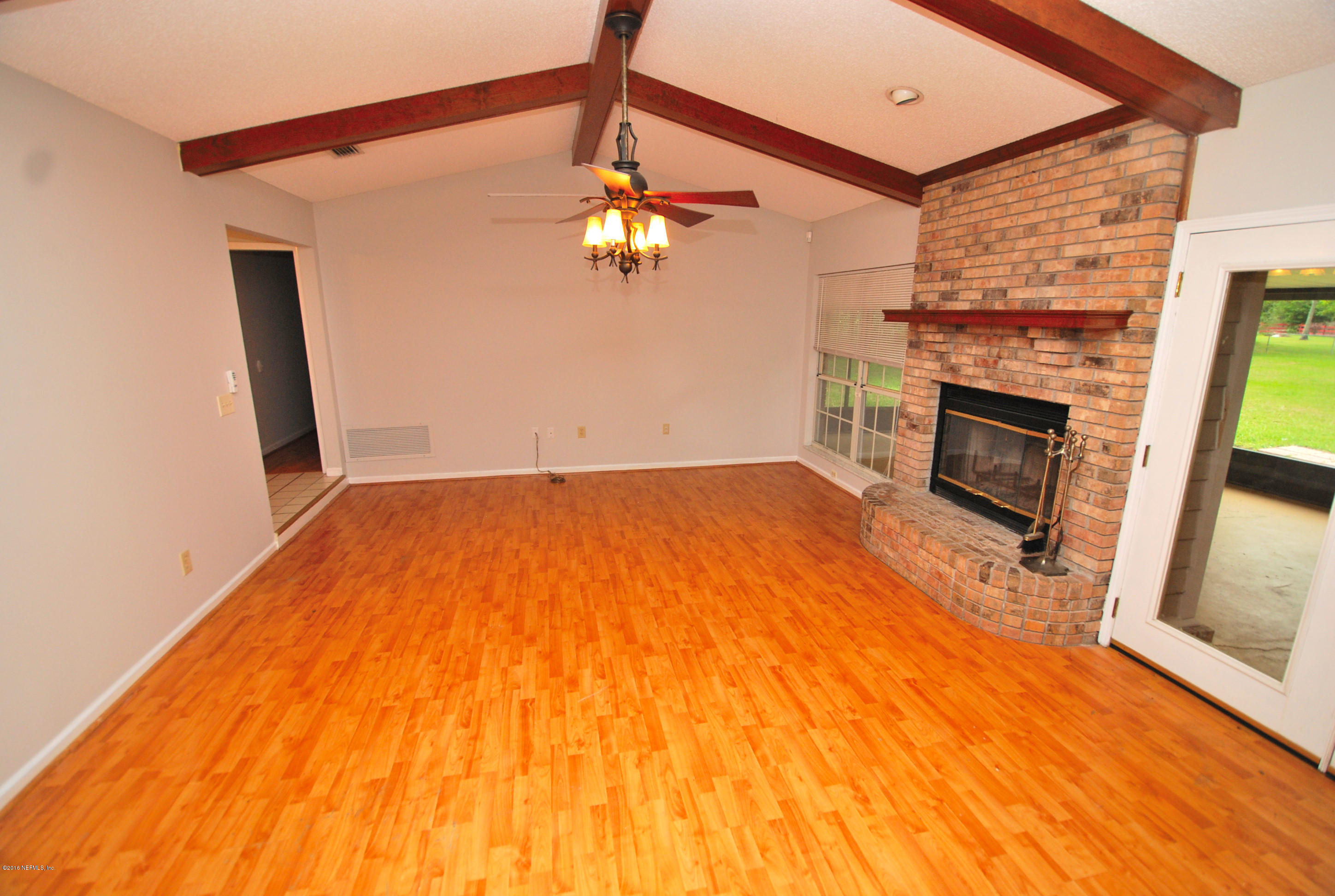 55581 Deer Run Road Callahan, FL 32011 - Photo 4 of 27 a view of empty room with wooden floor and fireplace