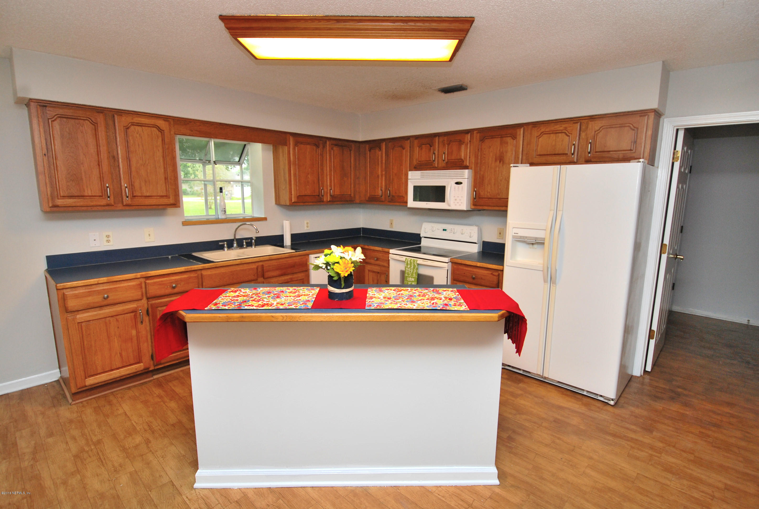 55581 Deer Run Road Callahan, FL 32011 - Photo 6 of 27 a kitchen with kitchen island a stove a refrigerator and a sink