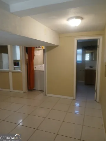 a view of a hallway to rooms and kitchen