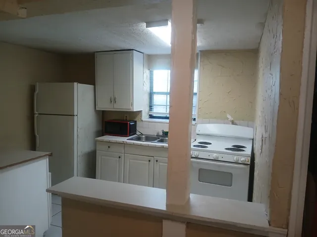 a kitchen with a refrigerator stove and sink