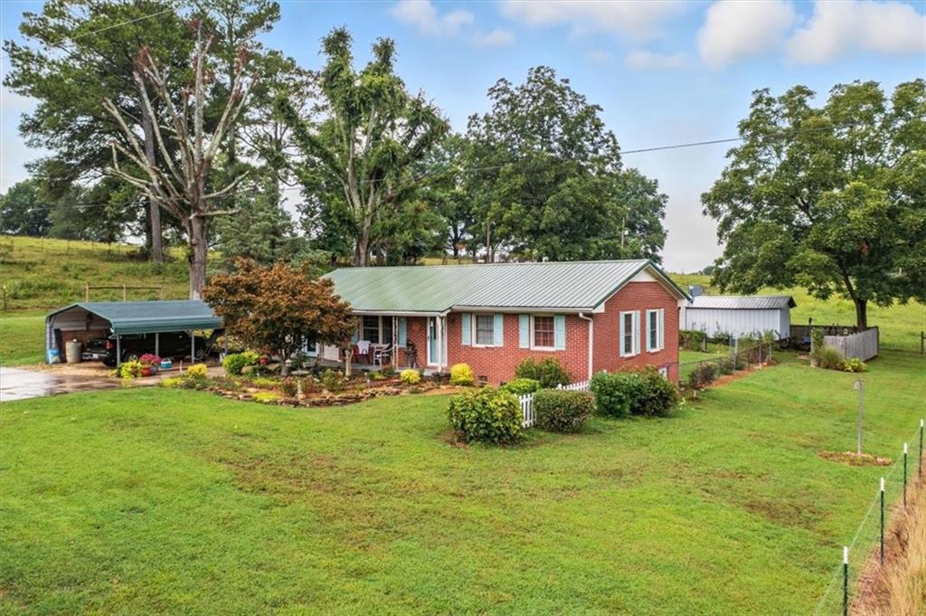 a view of a house with yard and sitting area