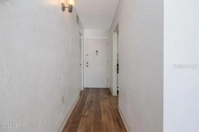a view of a hallway with wooden floor