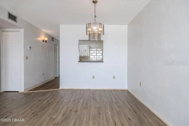a view of a hallway with wooden floor and entryway