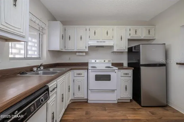 a kitchen with a sink stove and refrigerator