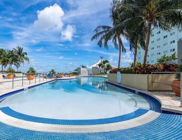 a swimming pool with outdoor seating and water view