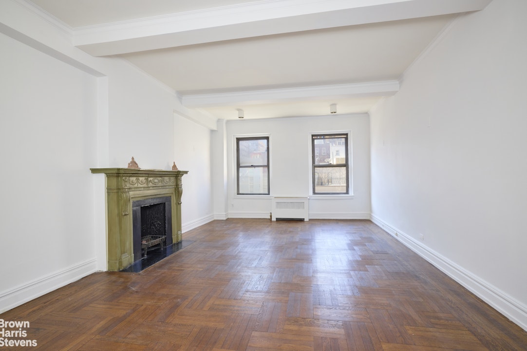 135 East 74th Street, Unit 6A Manhattan, NY 10021 - Photo 2 of 9 an empty room with windows and fireplace