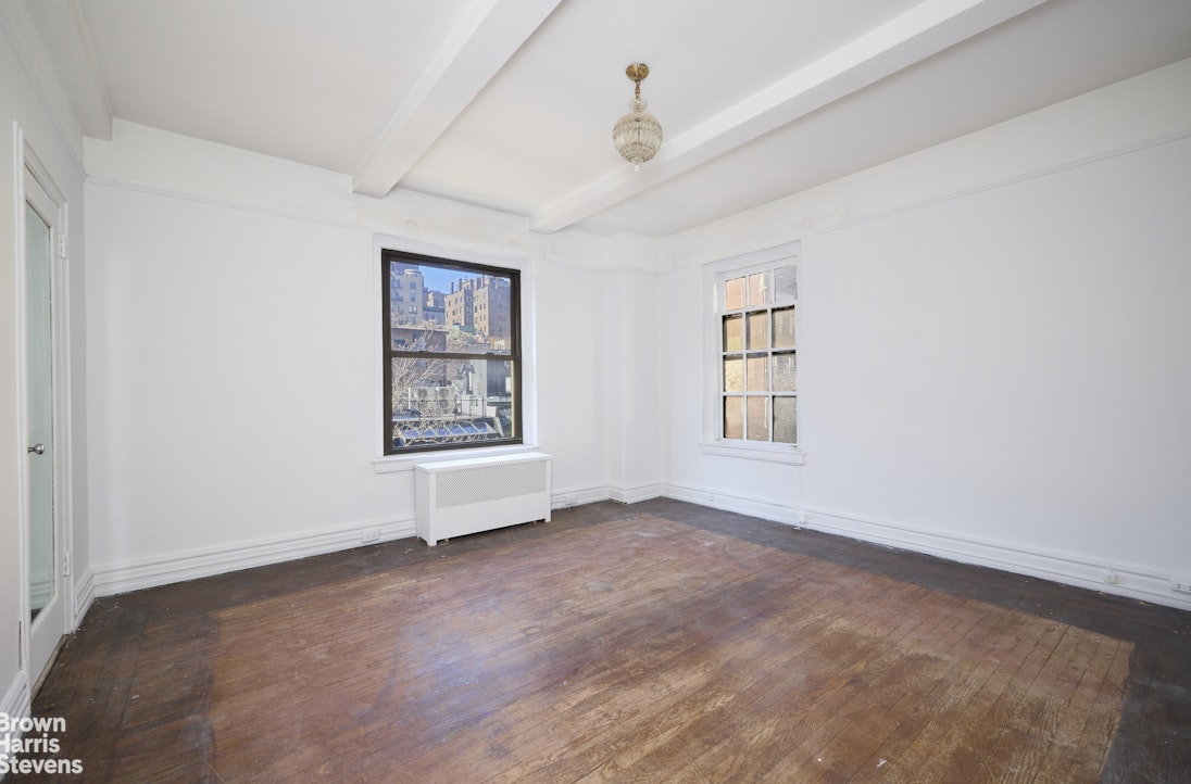 135 East 74th Street, Unit 6A Manhattan, NY 10021 - Photo 4 of 9 an empty room with windows and ceiling fan