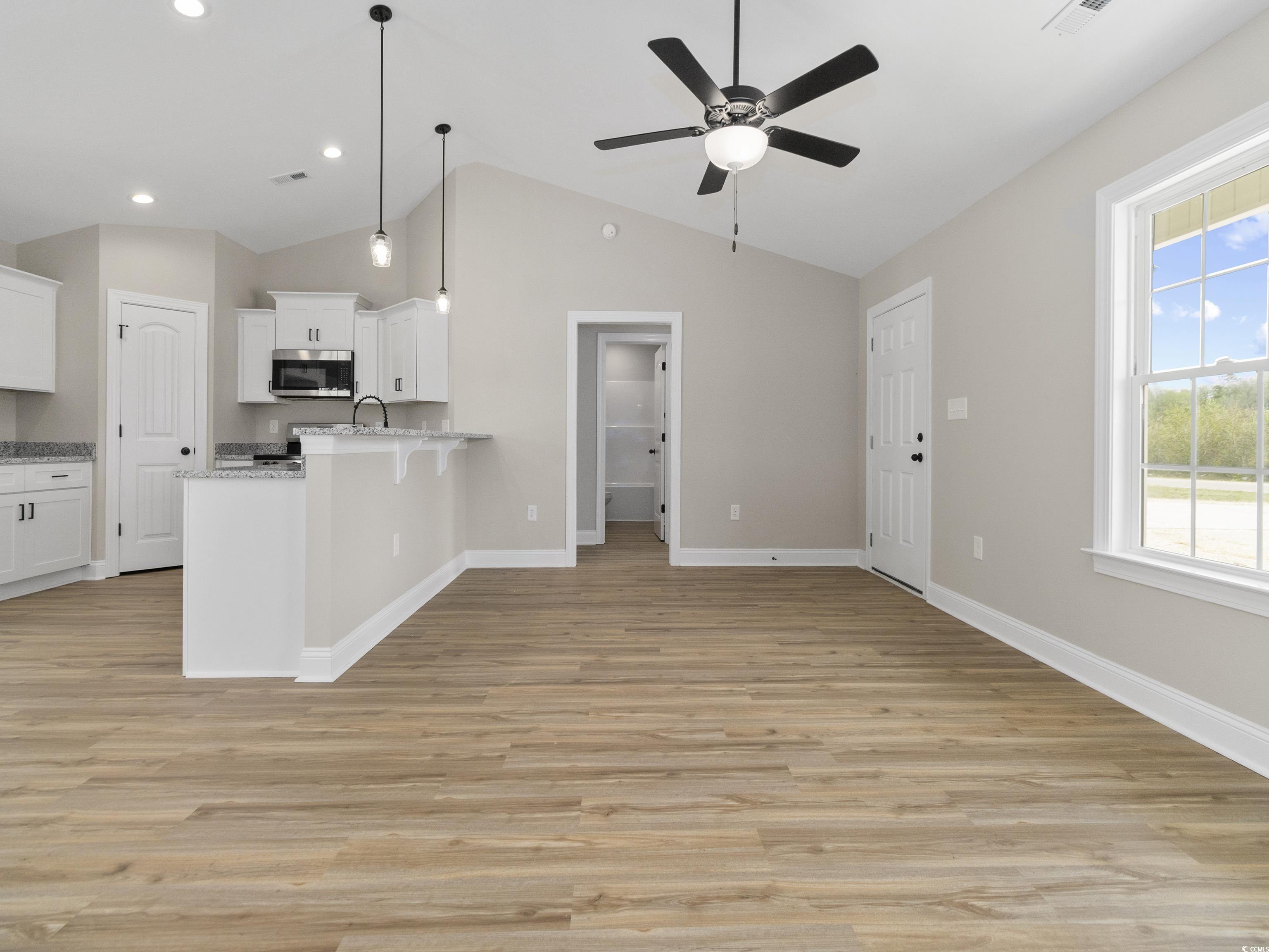 837 Highway 67 Loris Sc 29569 Loris, SC 29569 - Photo 30 of 31 Kitchen featuring open floor plan, a ceiling fan, a peninsula, stainless steel microwave, and white cabinetry