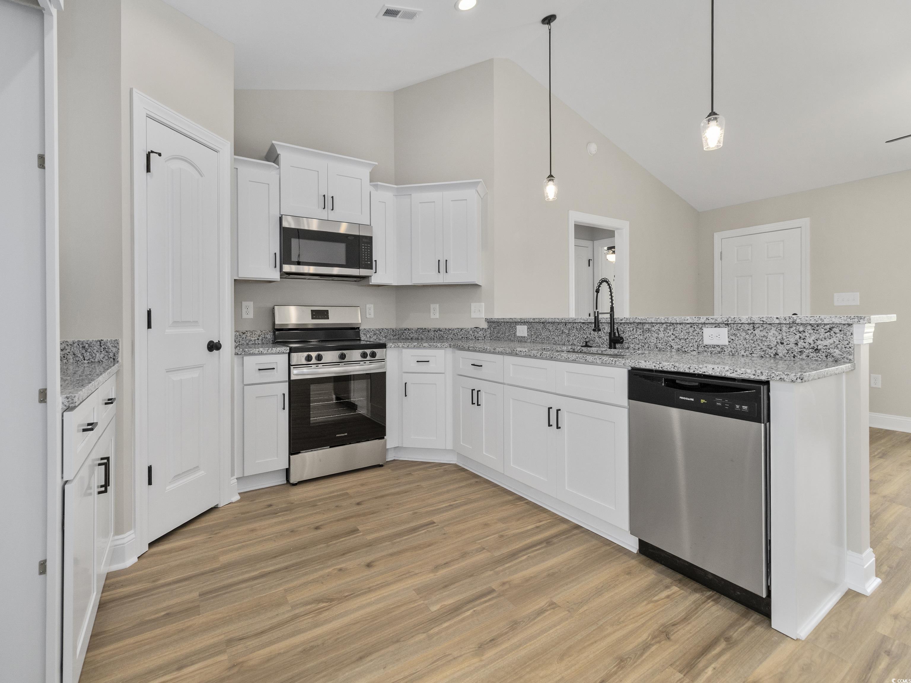 837 Highway 67 Loris Sc 29569 Loris, SC 29569 - Photo 11 of 31 Kitchen with light wood-style floors, a peninsula, white cabinets, a sink, and stainless steel appliances