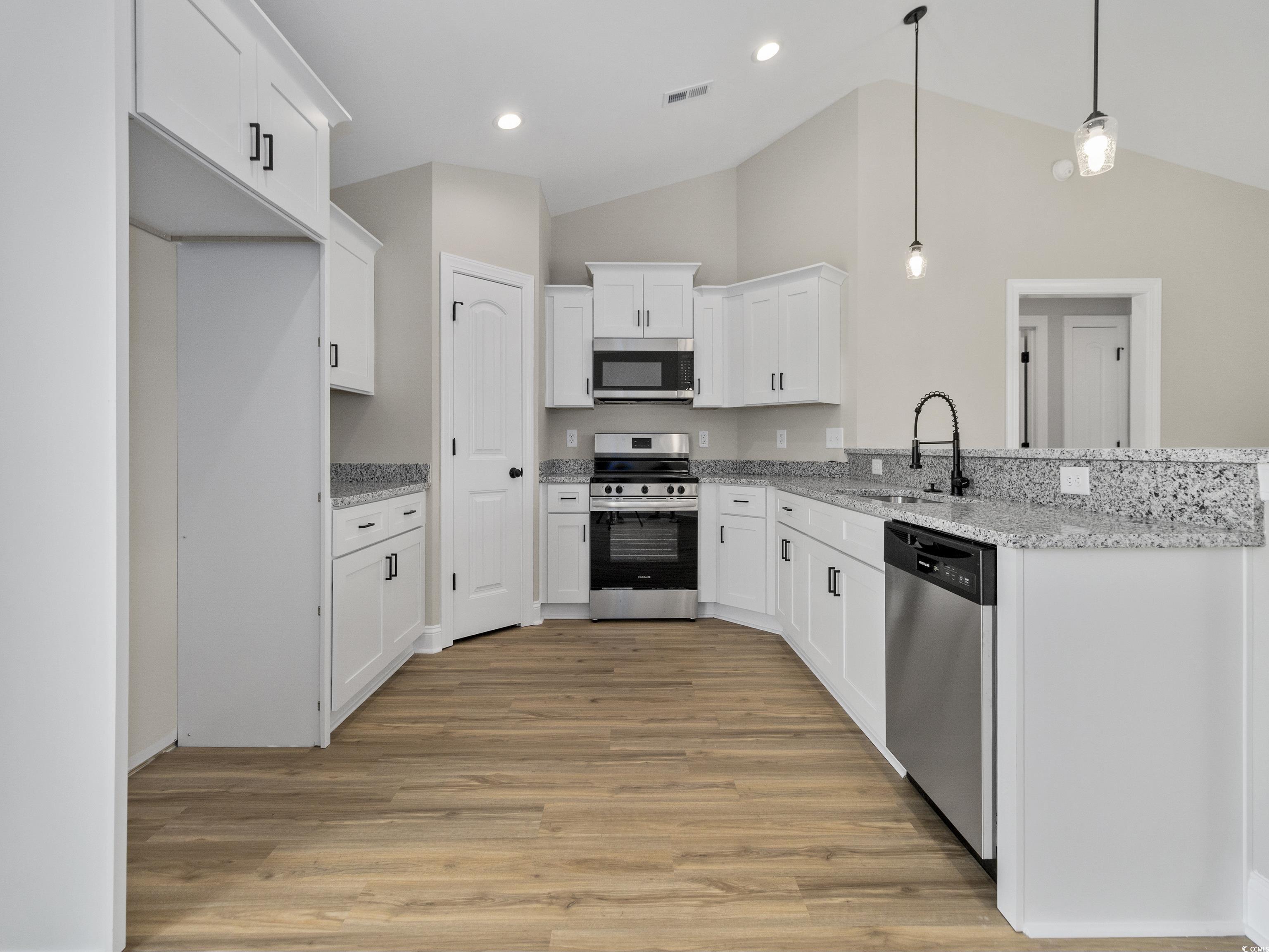 837 Highway 67 Loris Sc 29569 Loris, SC 29569 - Photo 19 of 31 Kitchen featuring visible vents, a sink, light wood-type flooring, appliances with stainless steel finishes, and a peninsula