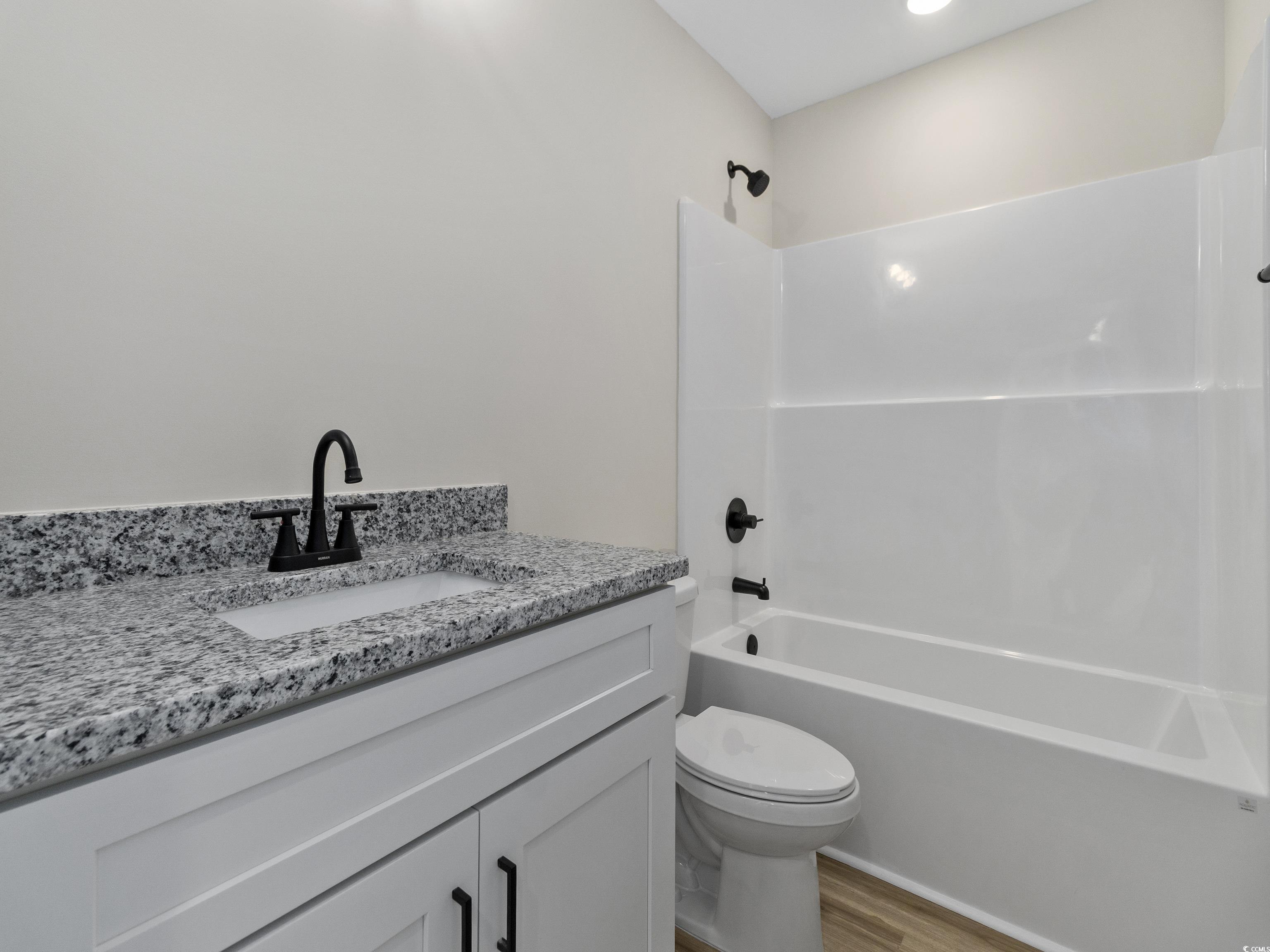 837 Highway 67 Loris Sc 29569 Loris, SC 29569 - Photo 28 of 31 Full bathroom featuring toilet, wood finished floors, vanity, and bathtub / shower combination