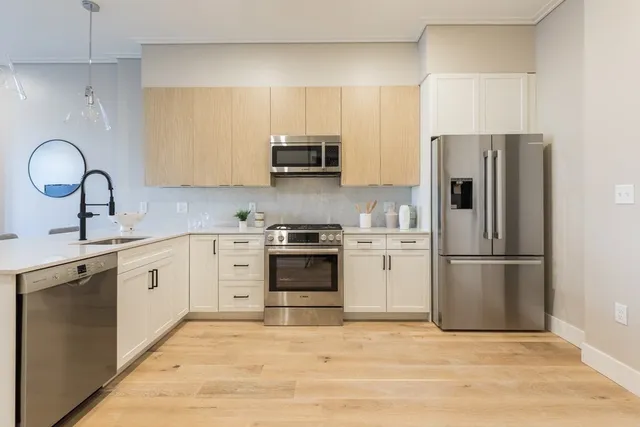 a kitchen with white cabinets and stainless steel appliances