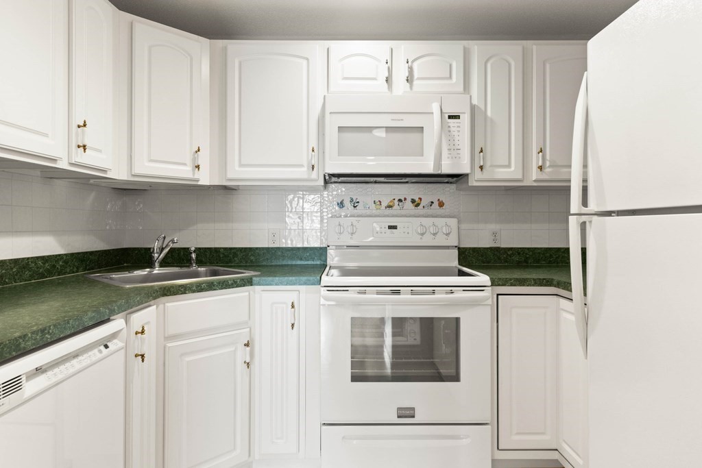 2 Ocean Avenue, Unit 3D Gloucester, MA 01930 - Photo 14 of 30 a kitchen with granite countertop white cabinets and white appliances