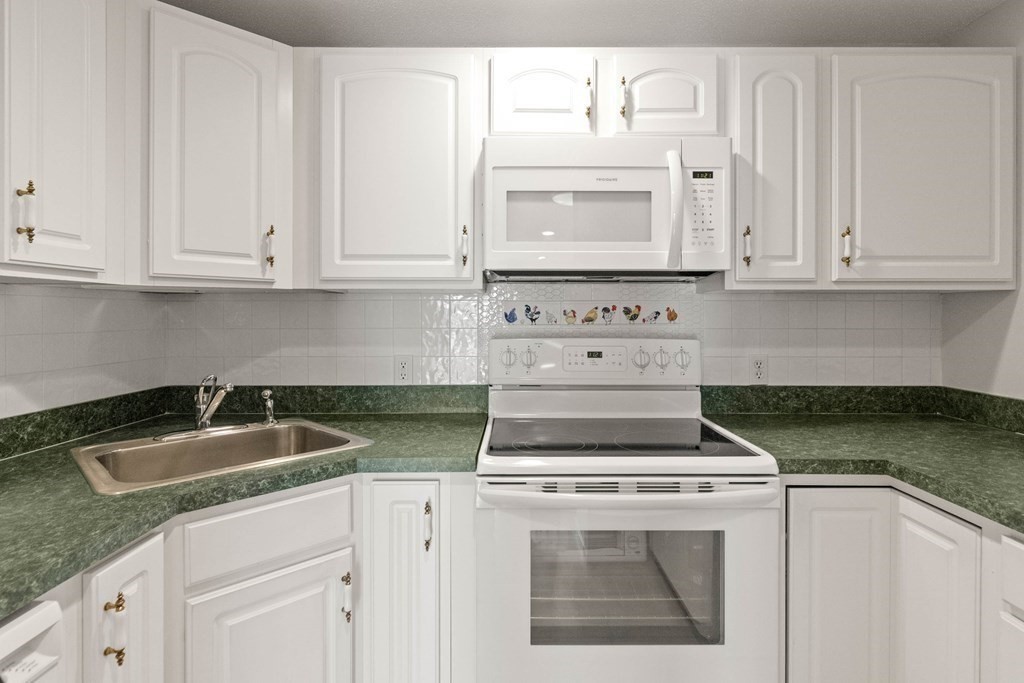 2 Ocean Avenue, Unit 3D Gloucester, MA 01930 - Photo 15 of 30 a kitchen with granite countertop white cabinets and a stove