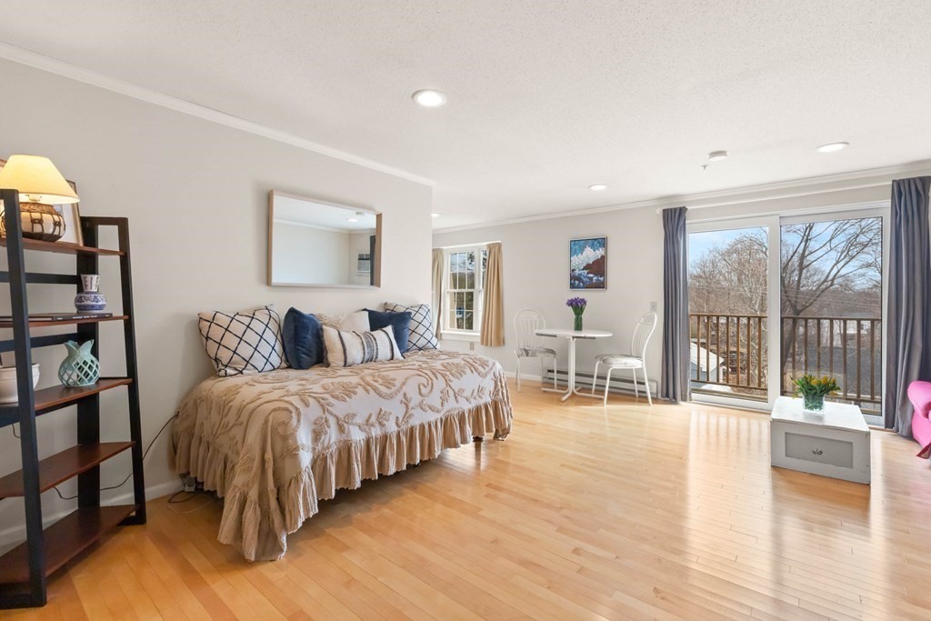 2 Ocean Avenue, Unit 3D Gloucester, MA 01930 - Photo 6 of 30 a living room with a balcony large bed and a wooden floor