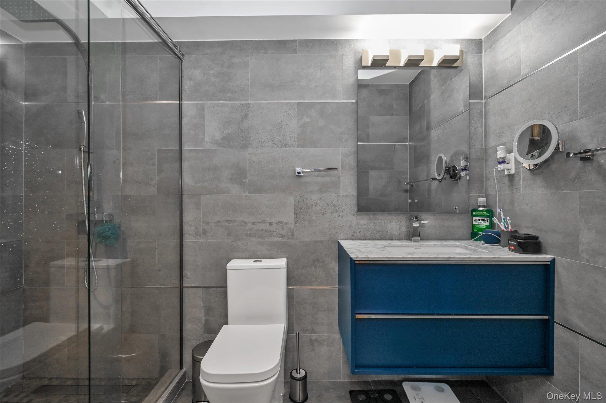 81-14 Queens Boulevard, Unit PH6C Queens, NY 11373 - Photo 12 of 19 Bathroom with vanity, a stall shower, and tile walls