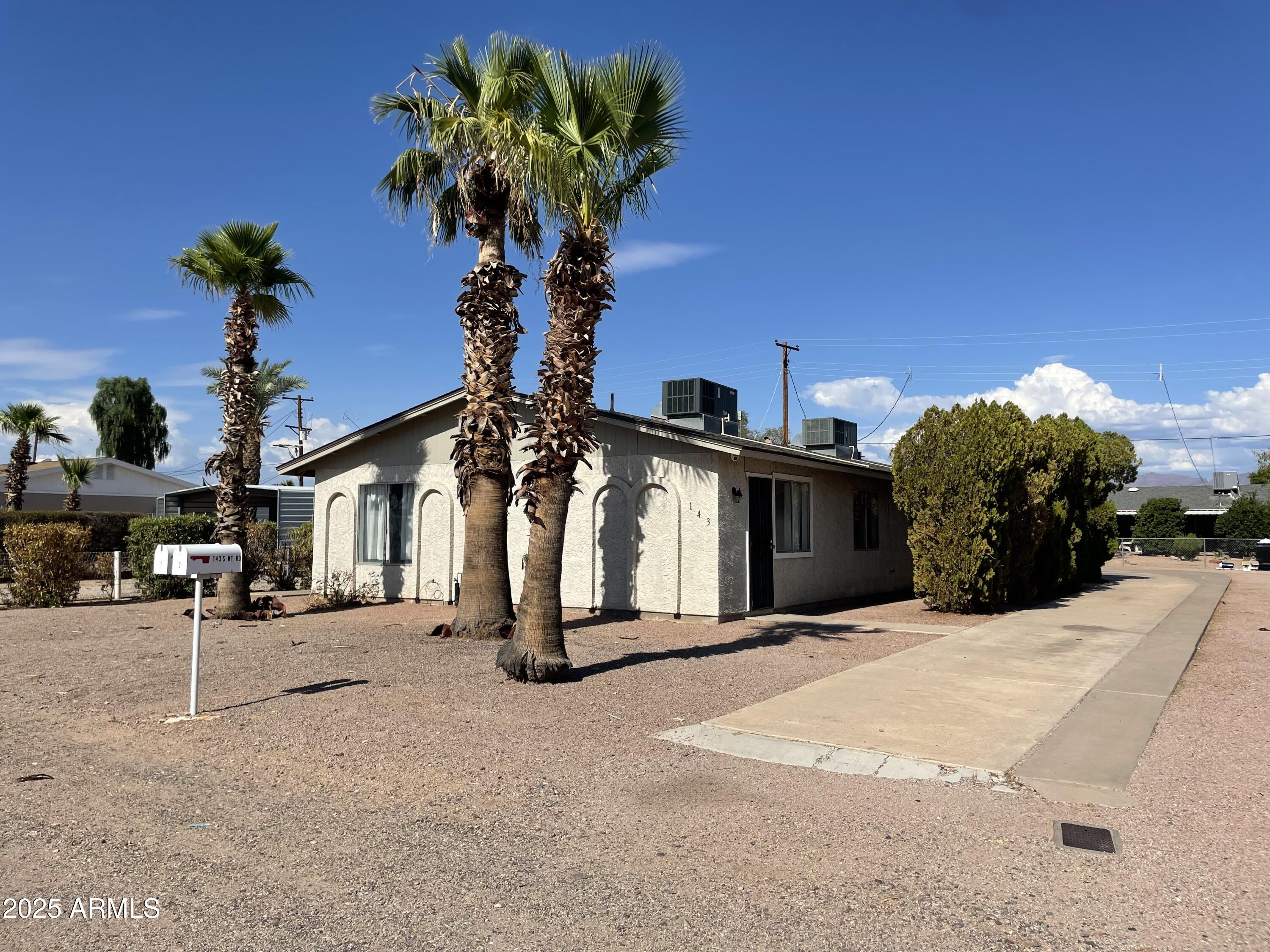 143 South Mountain Road, Unit 1 Apache Junction, AZ 85120 - Photo 15 of 17 a front view of a house with a yard and garage