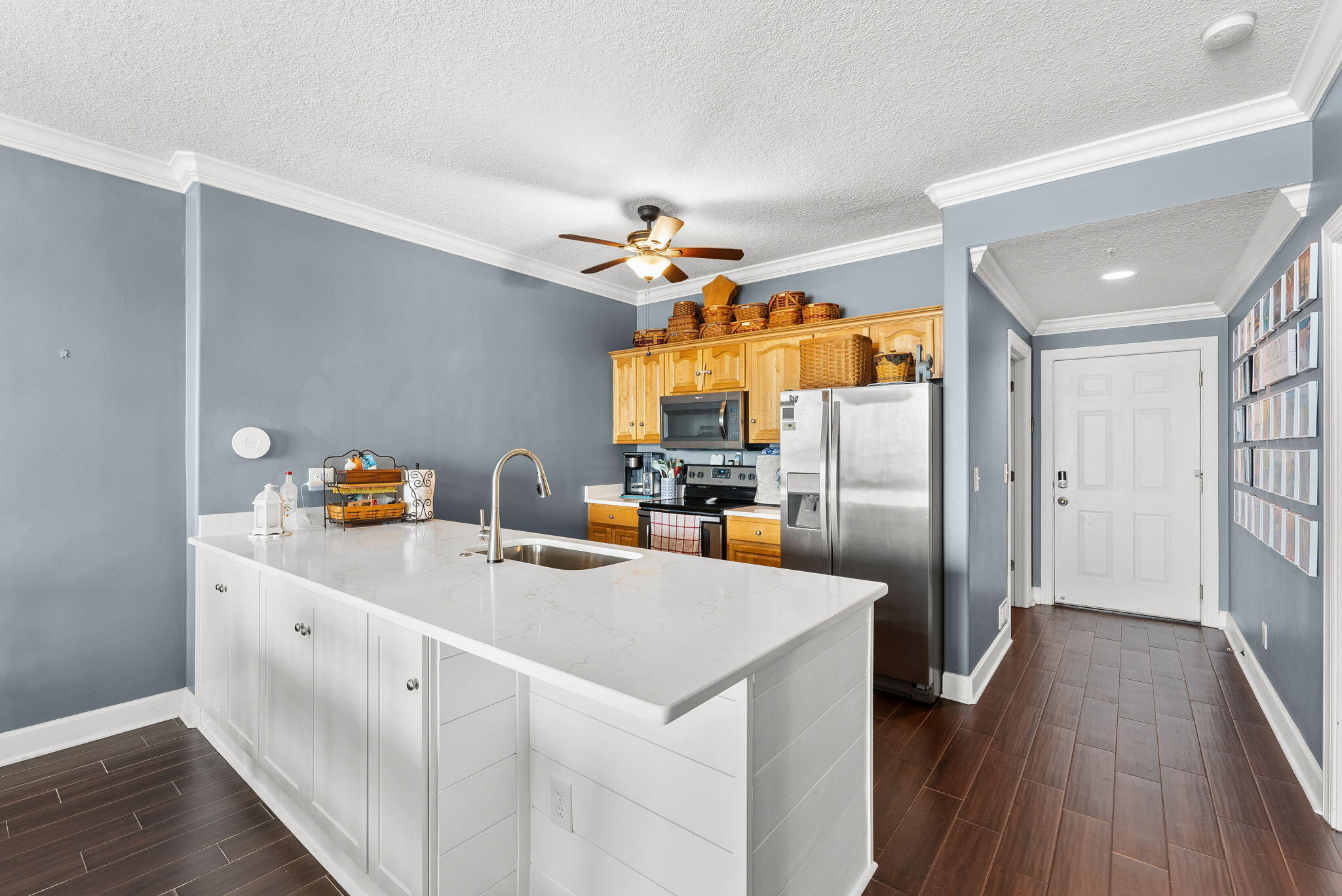 14415 Front Beach Road, Unit 1305 Panama City Beach, FL 32413 - Photo 11 of 47 a kitchen with stainless steel appliances a sink dishwasher a refrigerator a stove and white cabinets with wooden floor