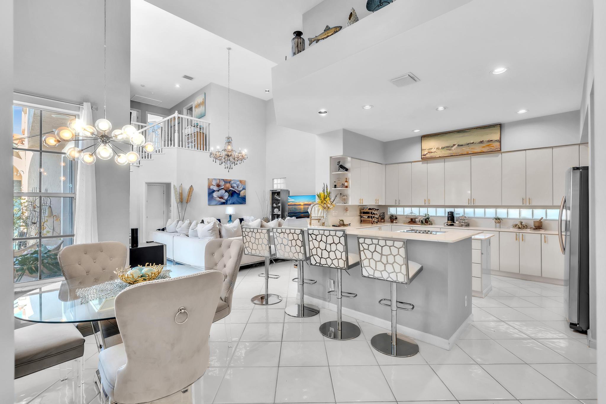6230 Northwest 23rd Street Boca Raton, FL 33434 - Photo 21 of 90 a living room with kitchen island furniture and a chandelier