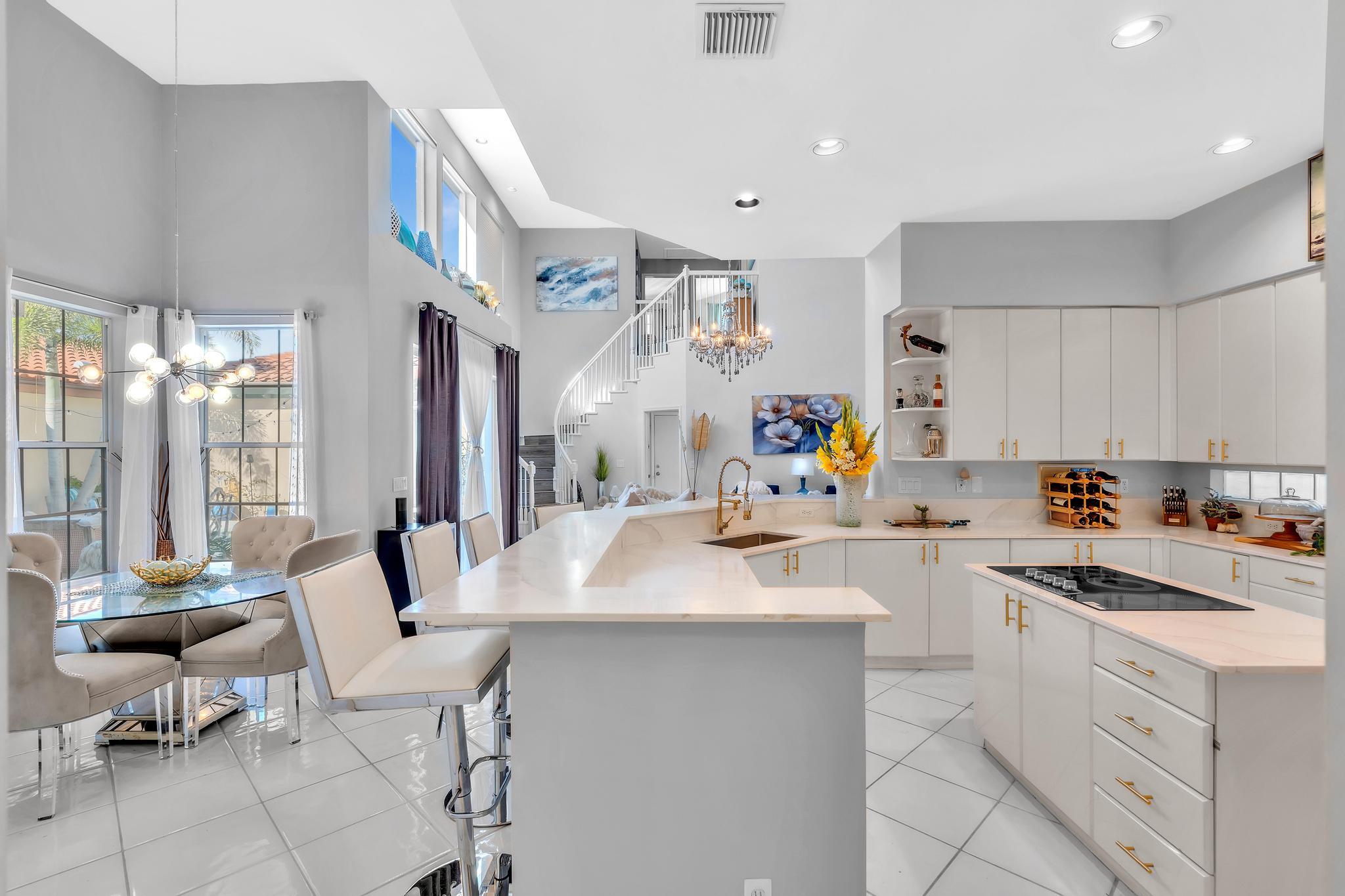 6230 Northwest 23rd Street Boca Raton, FL 33434 - Photo 26 of 90 a kitchen that has a sink and chairs in it