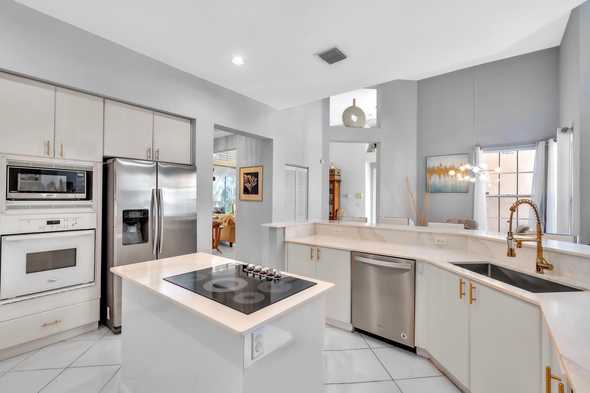 6230 Northwest 23rd Street Boca Raton, FL 33434 - Photo 28 of 90 a kitchen with white cabinets and stainless steel appliances