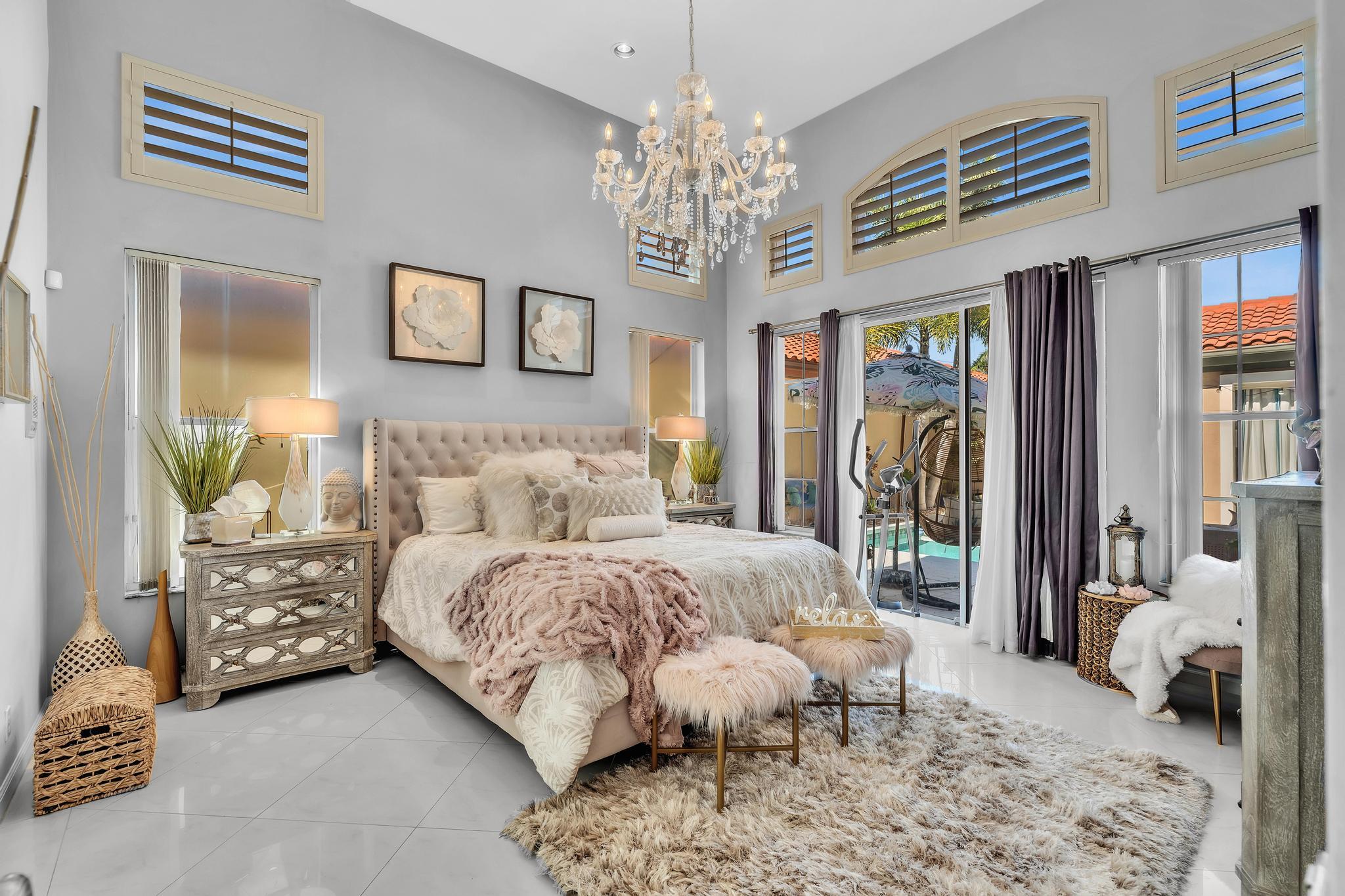 6230 Northwest 23rd Street Boca Raton, FL 33434 - Photo 37 of 90 a spacious bedroom with bed and a chandelier