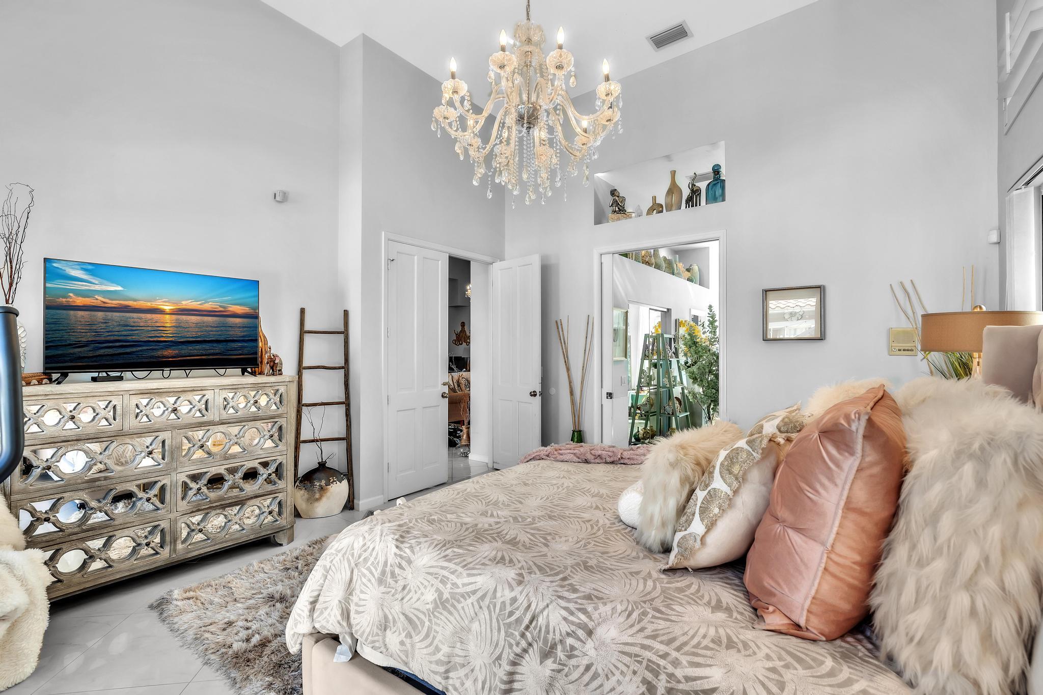 6230 Northwest 23rd Street Boca Raton, FL 33434 - Photo 39 of 90 a bedroom with a bed and a flat screen tv