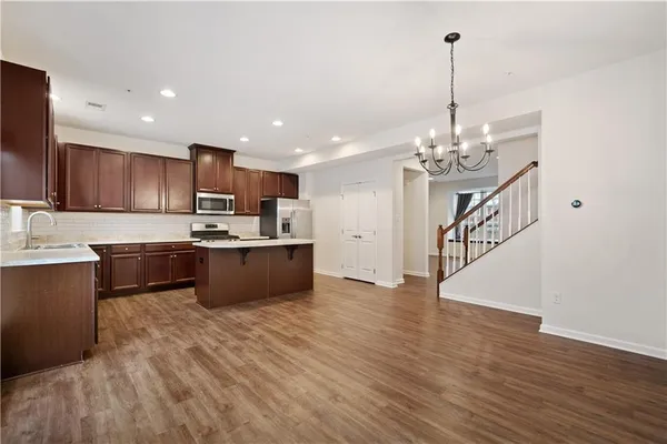 a large kitchen with kitchen island a sink dishwasher a refrigerator and a counter top space