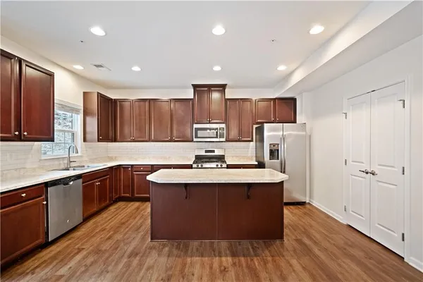 a kitchen with stainless steel appliances granite countertop a sink stove and refrigerator