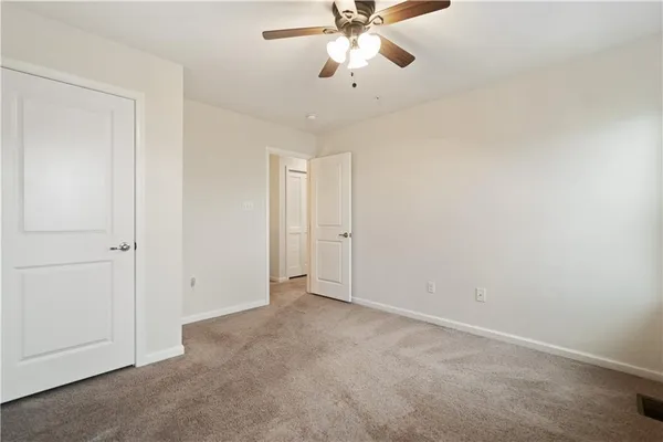 a view of an empty room and chandelier fan