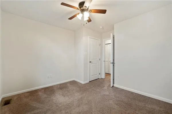 an empty room with a ceiling fan and a window