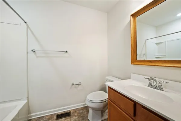 a bathroom with a sink vanity mirror and toilet