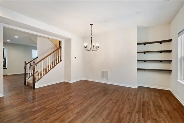a view of a room with wooden floor staircase and a ceiling fan