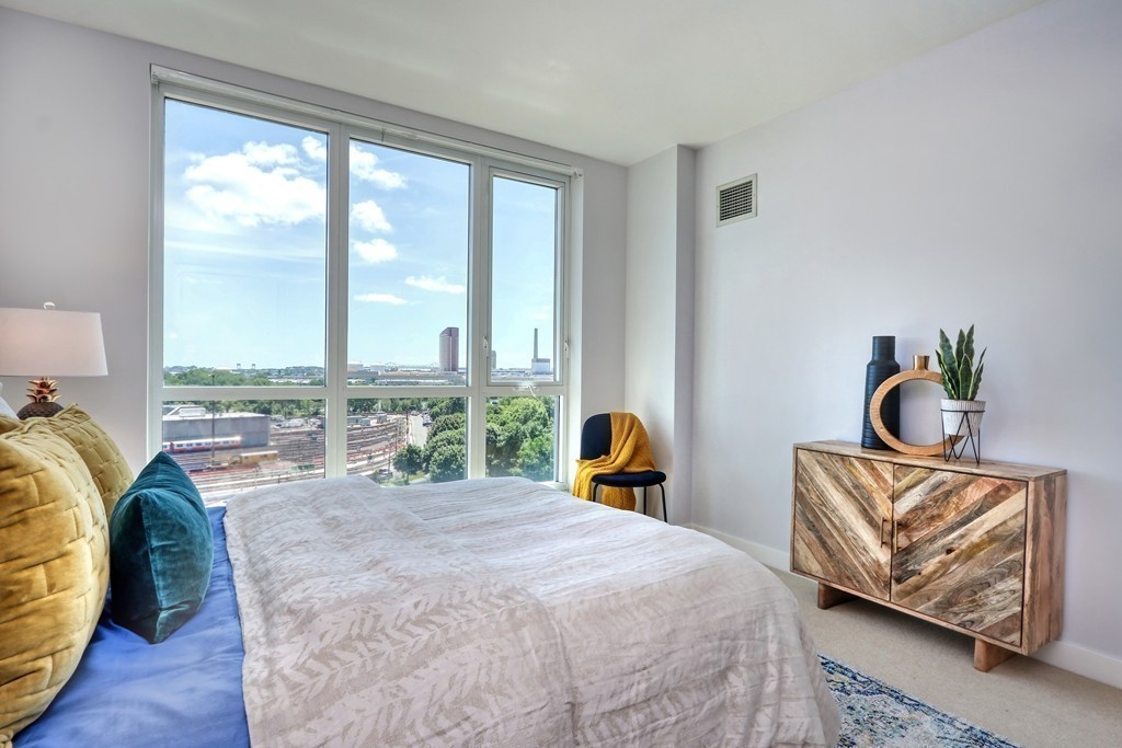 100 Station Landing, Unit 906 Medford, MA 02155 - Photo 14 of 28 a bedroom with furniture and a large window