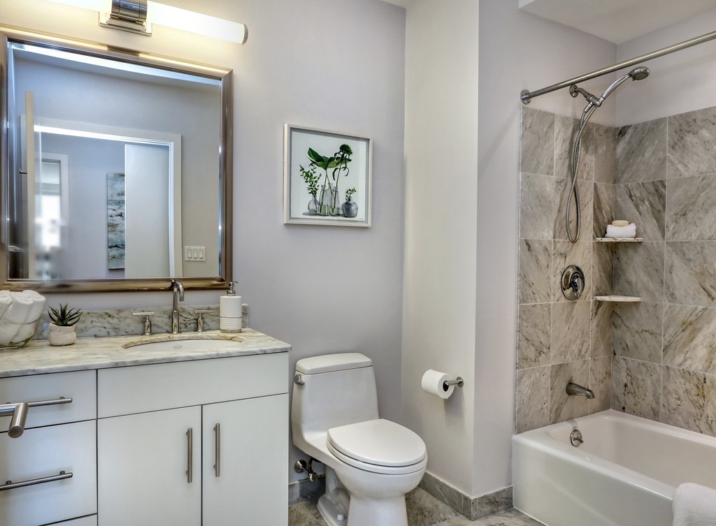 100 Station Landing, Unit 906 Medford, MA 02155 - Photo 16 of 28 a bathroom with a sink a toilet and shower