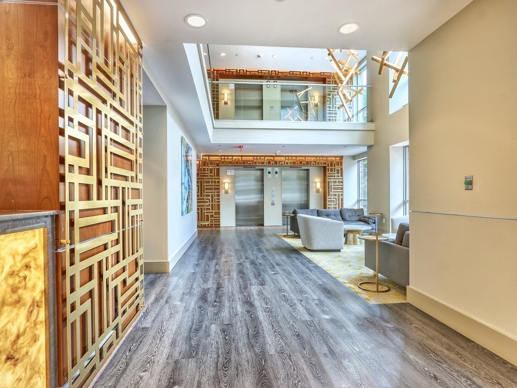 100 Station Landing, Unit 906 Medford, MA 02155 - Photo 18 of 28 a living room with furniture and a wooden floor