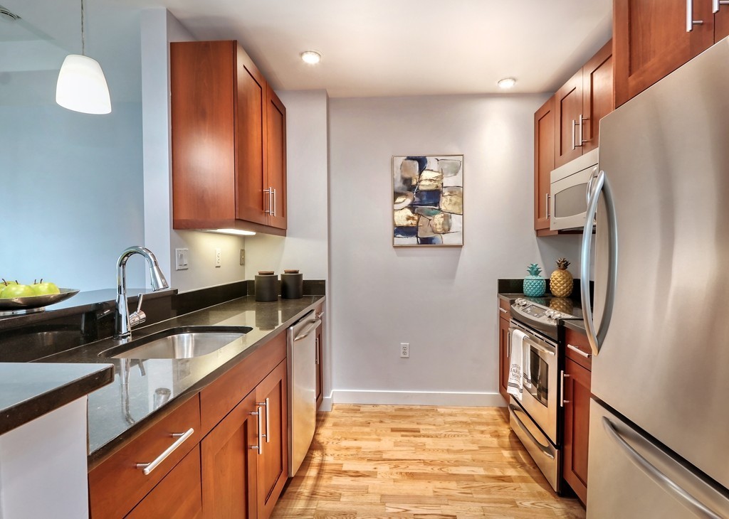 100 Station Landing, Unit 906 Medford, MA 02155 - Photo 4 of 28 a kitchen with stainless steel appliances granite countertop a sink stove and refrigerator
