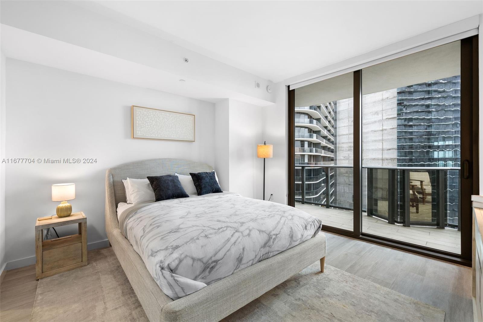 45 Southwest 9th Street, Unit 3802 Miami, FL 33130 - Photo 2 of 40 a bedroom with a large bed and a chandelier