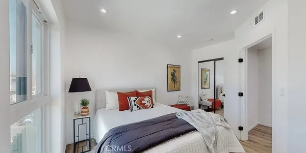 a bedroom with a bed and wooden floor