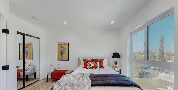 a bedroom with a bed and wooden floor