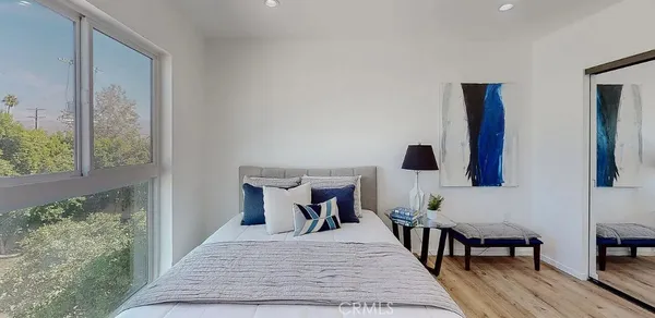 a bedroom with a bed and wooden floor
