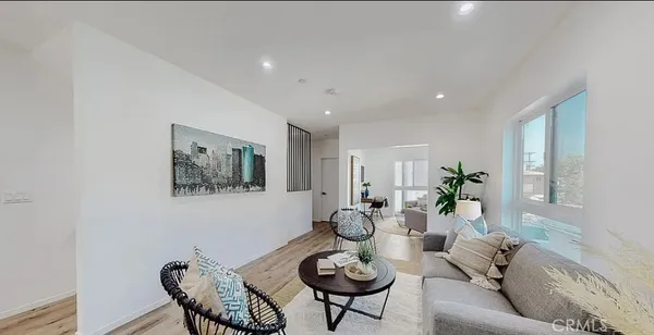 a living room with furniture a mirror and a potted plant