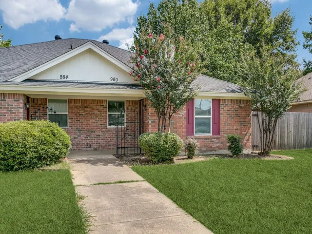a front view of a house with a garden and yard