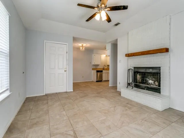 a view of a livingroom with a fireplace and window