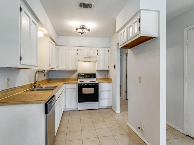 a kitchen with stainless steel appliances granite countertop a sink and a stove