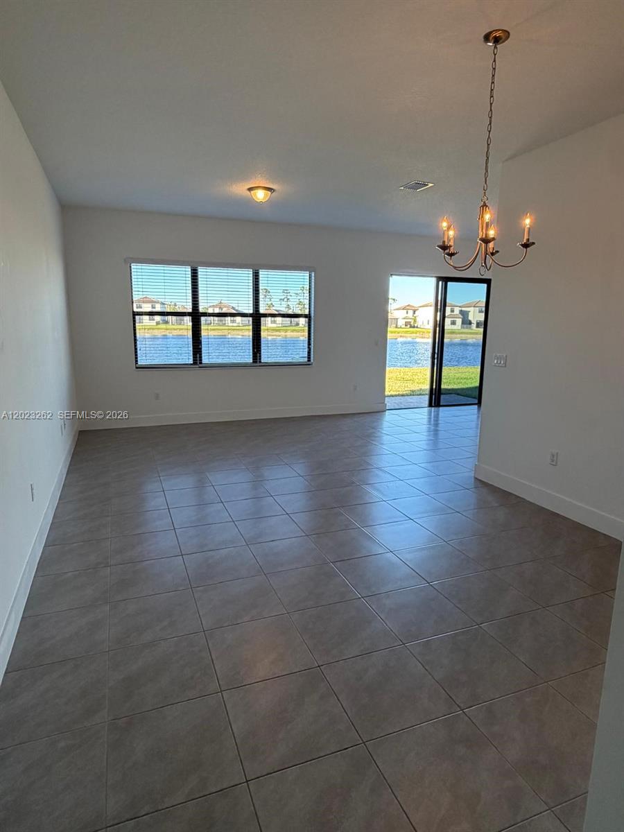 5669 Cerva Lane, Unit 5669 Immokalee, FL 34142 - Photo 3 of 32 wooden floor in an empty room with a window