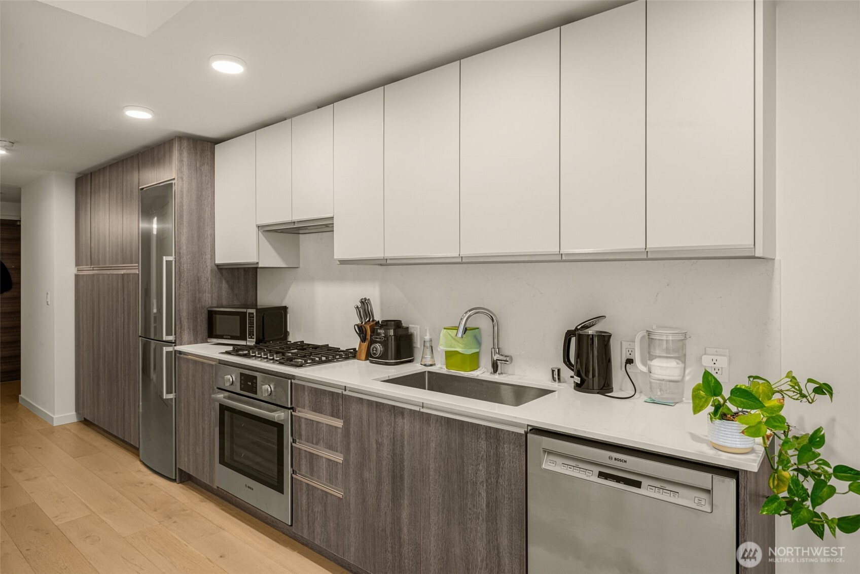 800 Columbia Street, Unit 808 Seattle, WA 98104 - Photo 12 of 38 a kitchen with stainless steel appliances granite countertop a sink a stove and a refrigerator