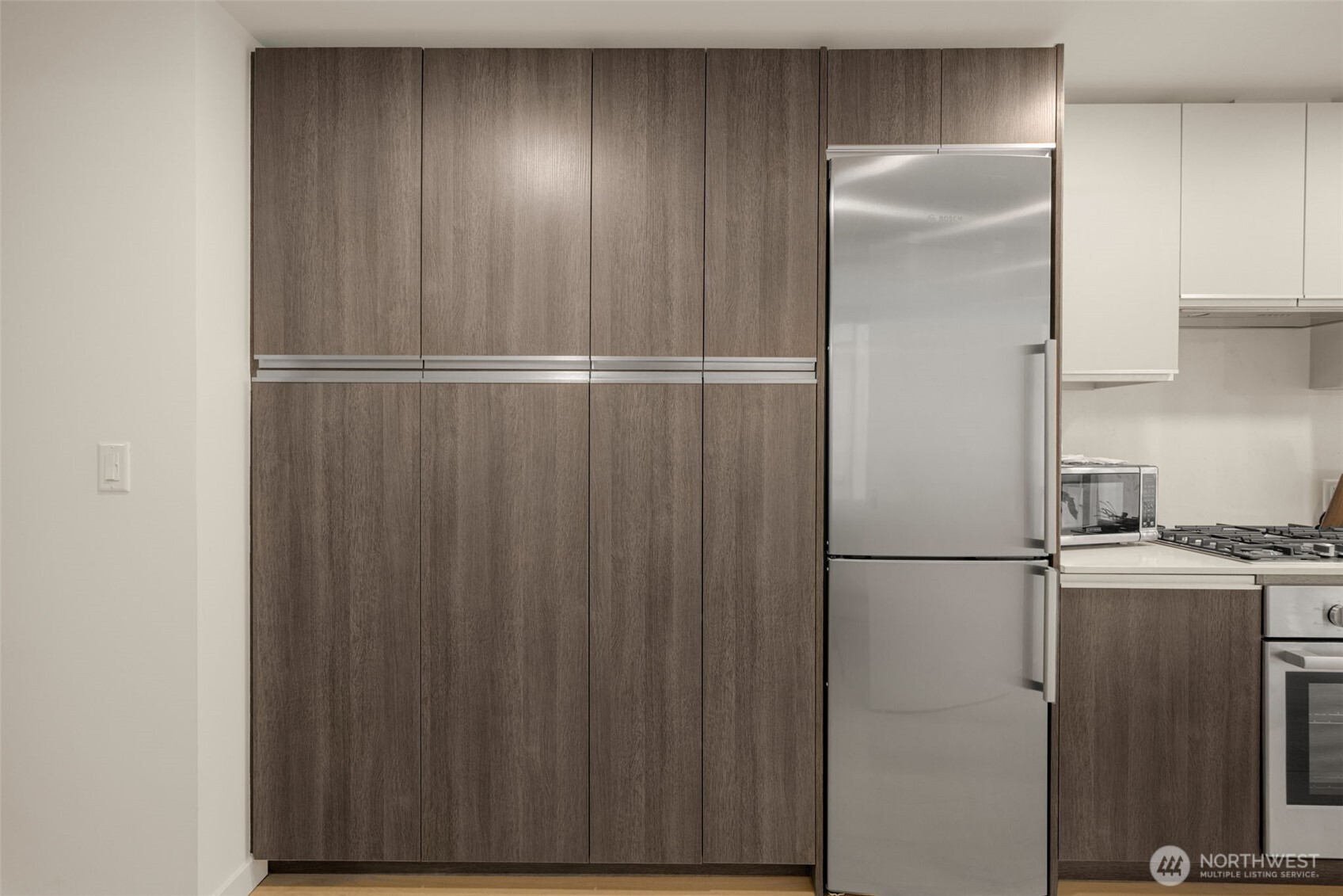 800 Columbia Street, Unit 808 Seattle, WA 98104 - Photo 19 of 38 a view of a refrigerator in kitchen and wooden floor